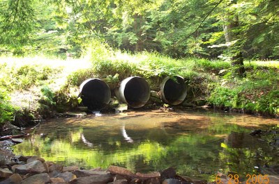 Culverts on Bobbs Creek in Pennsylvania Photo showing the outlet for one of the culverts to be replaced in Bobbs Creek, Pennsylvania.  Note the elevation between the culvert ends and the water level and the concentration of flow through only one of the three culverts.